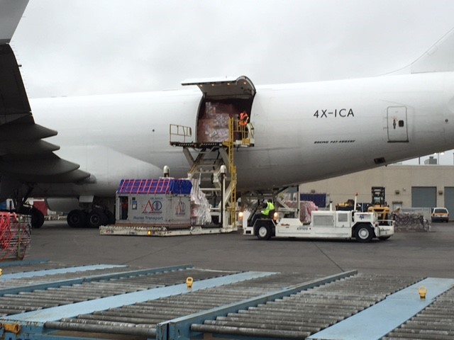 horse box stall being loaded into airplane